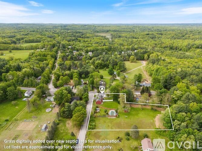 An aerial view of a green area with a red marker and a white outline.