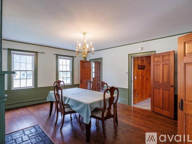 A room with a table and chairs and a chandelier.