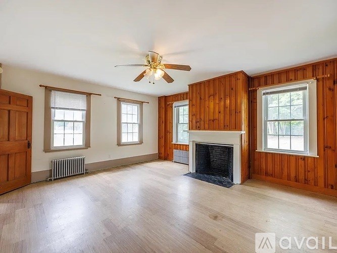 A room with wooden walls and a fireplace is available for rent.