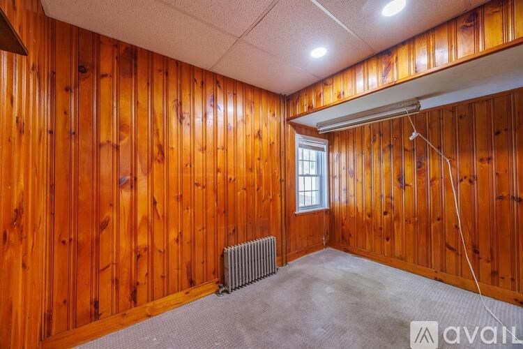A room with wooden walls and a window.