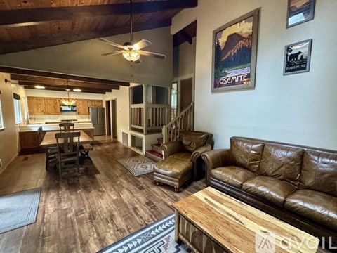 A living room with a brown leather couch and a wooden coffee table.