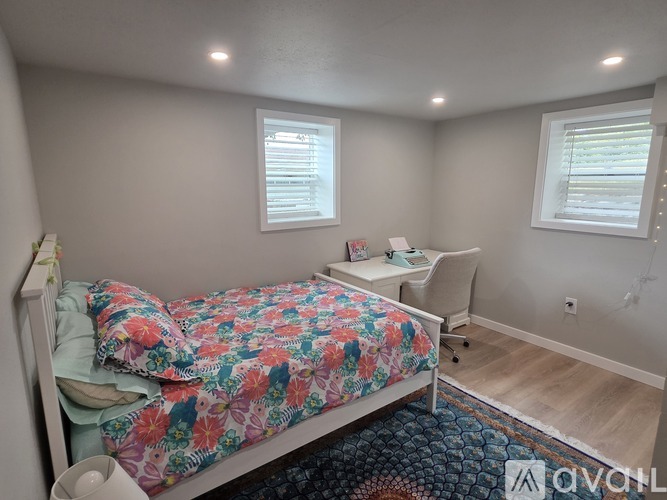 A bedroom with a floral bedspread and a white bed.