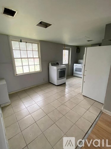 A kitchen with white appliances and a window.