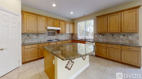 A kitchen with wooden cabinets and granite countertops.
