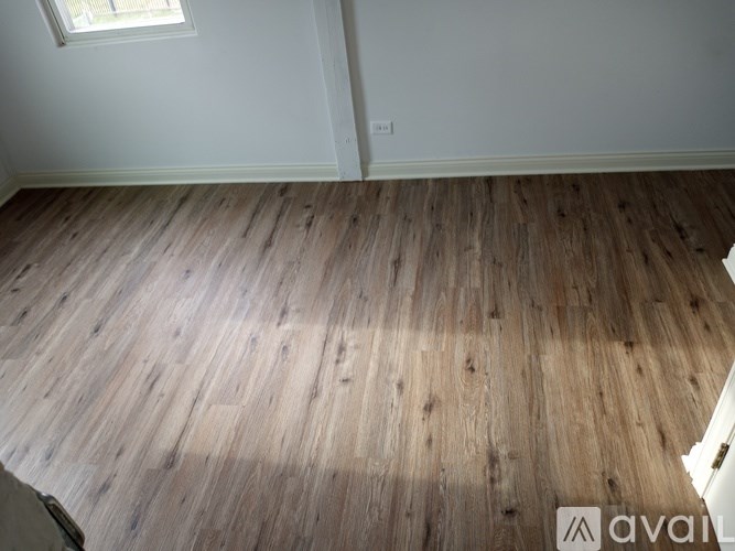 A room with wooden flooring and a window.