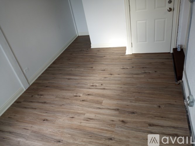 A hallway with wooden floors and white walls.