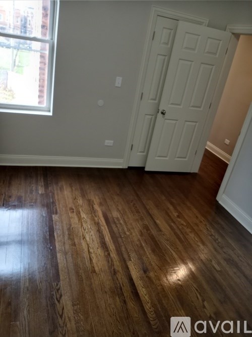 A room with wooden flooring and a white door.