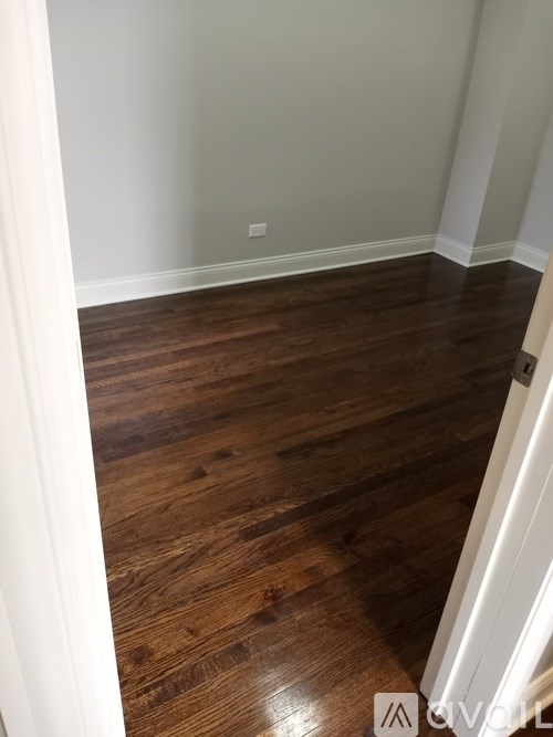 A hallway with wooden floors and white walls.