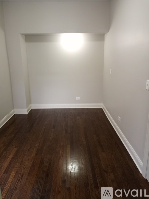 A room with wooden flooring and white walls.