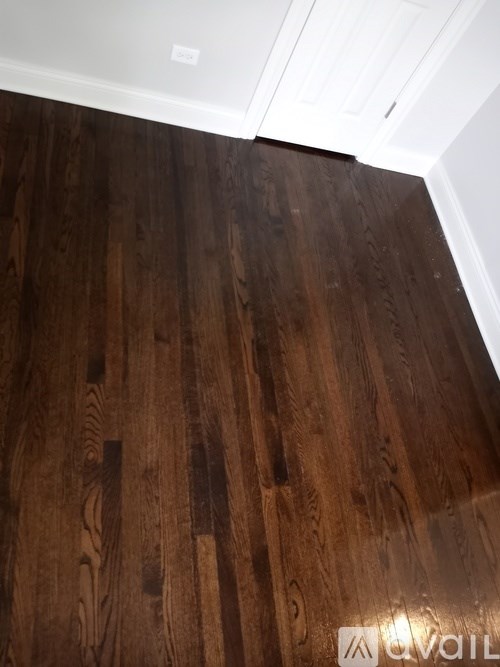 A wooden floor with a white ceiling and a logo on the floor.