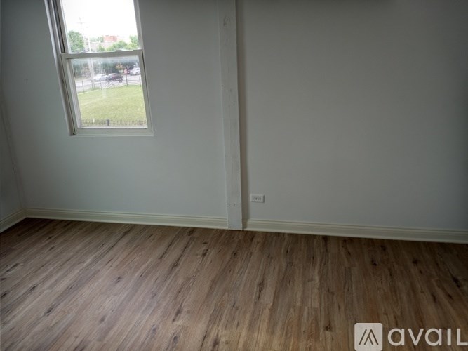 A room with wooden flooring and a window.