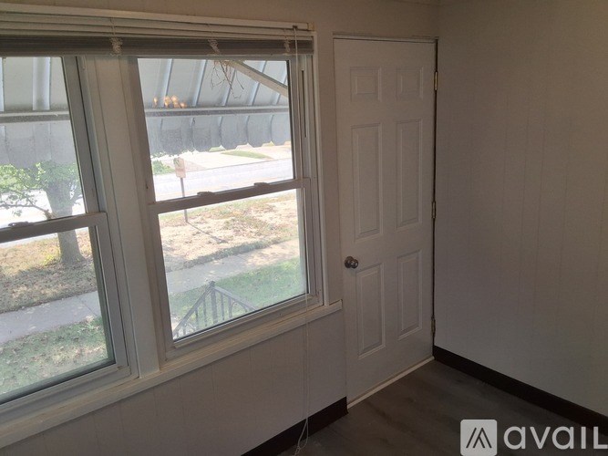 A room with a window and a door is available for rent.