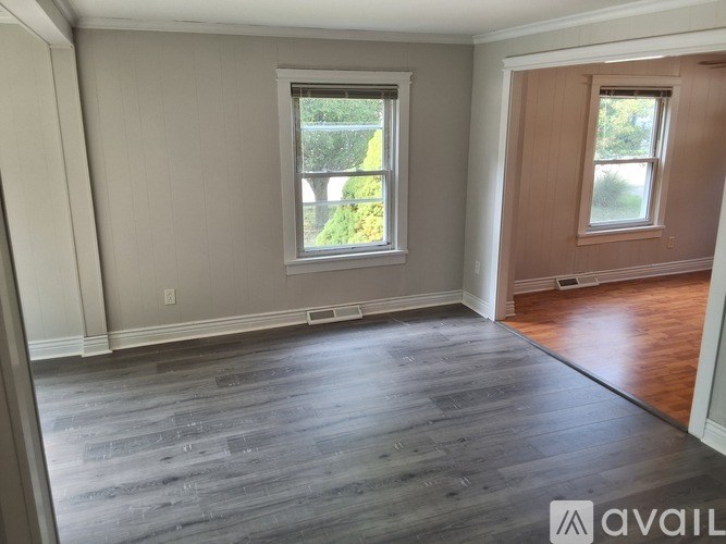 A room with a window and wooden flooring.