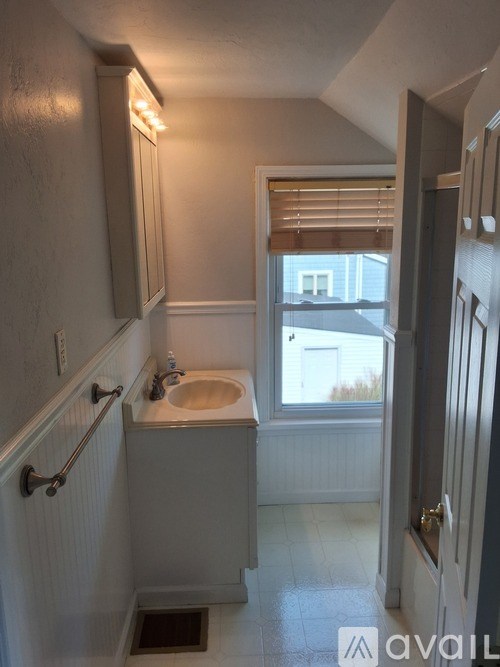 A small bathroom with a sink and a window.