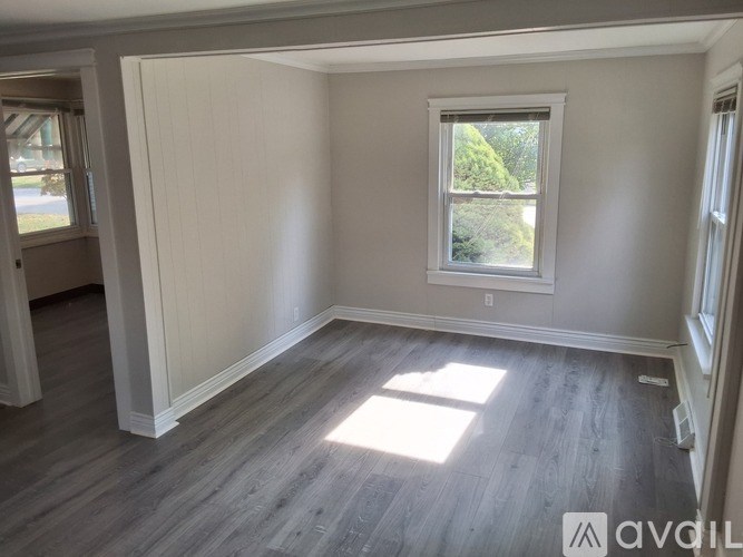 A room with a window and wooden flooring.