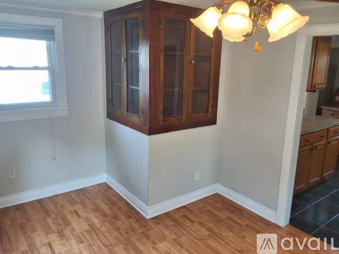 A room with wooden floors and a cabinet with glass doors.