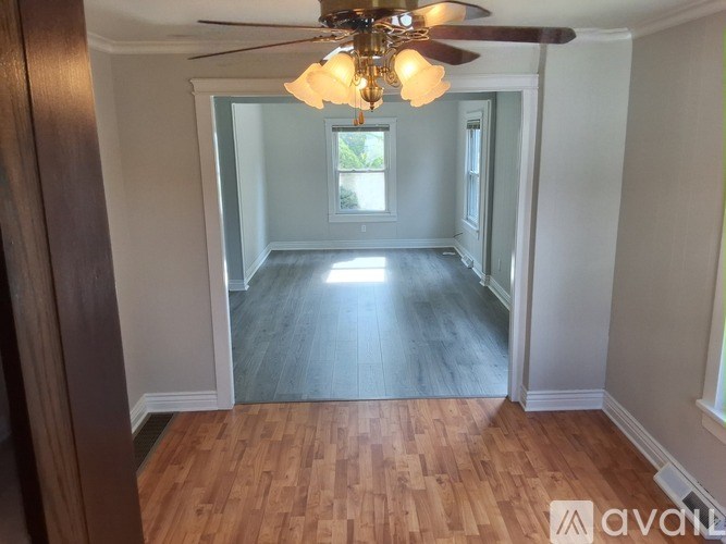 A room with wooden floors and a ceiling fan.