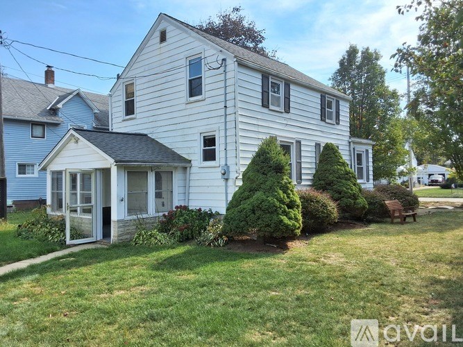A white house with a green lawn in front.