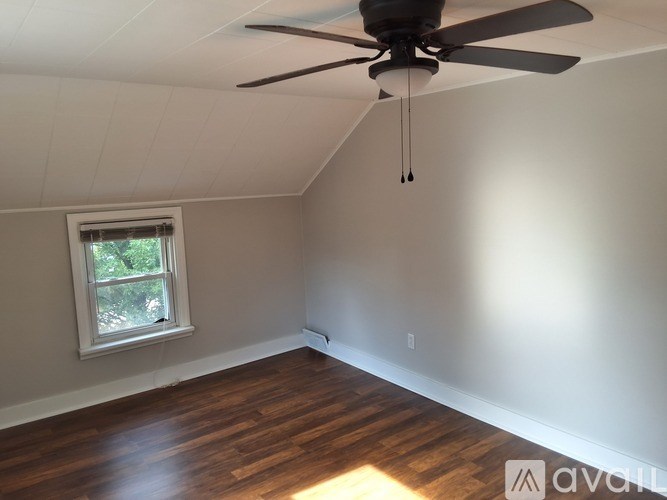 A room with a ceiling fan and a window.