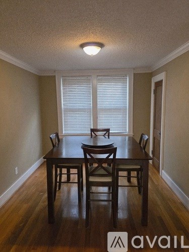 A brown wooden dining table with four chairs.
