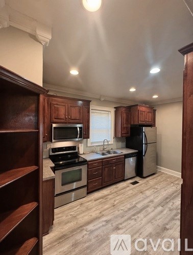 A kitchen with wooden cabinets and a black refrigerator.