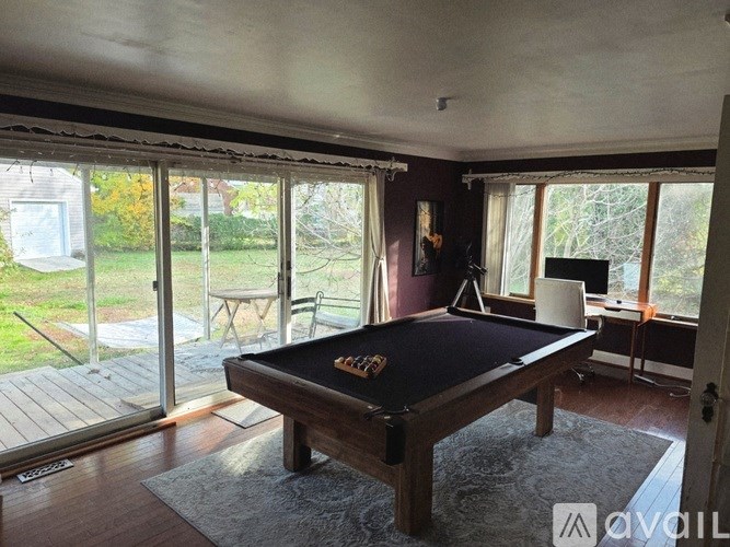 A pool table in a room with sliding glass doors.