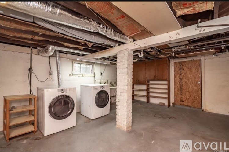 A laundry room with two washing machines and a dryer.