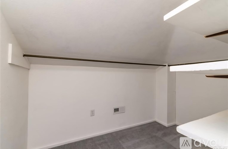 A white room with a grey carpet and a white table.