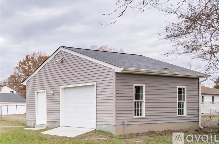 A small garage with a white door and windows is available for rent.