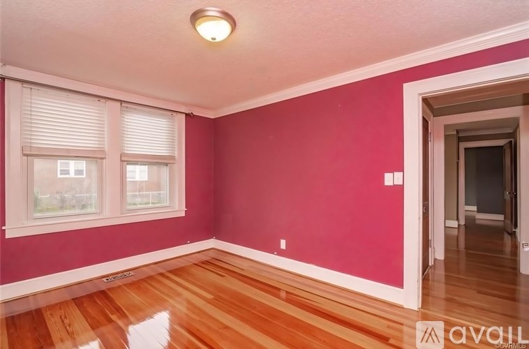 A room with pink walls and wooden floors.