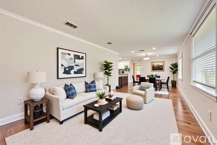 A living room with a white couch, a coffee table, and a rug.