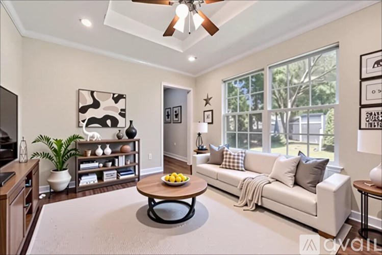 A living room with a white couch and a coffee table in the center.