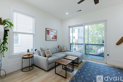 A living room with a grey couch, a coffee table, and a painting on the wall.