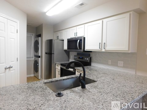 A kitchen with granite countertops and white cabinets.