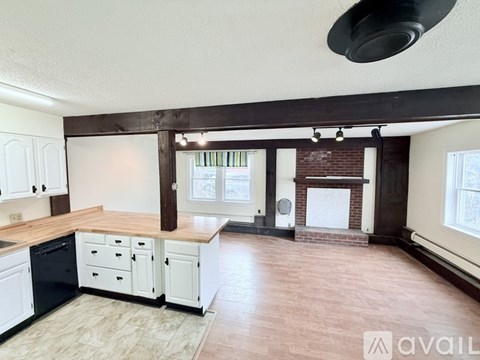 A kitchen with white cabinets and a wooden island.