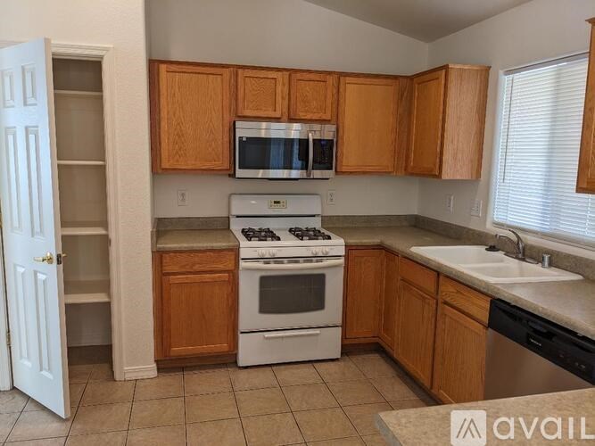 A kitchen with wooden cabinets and a white stove top oven.