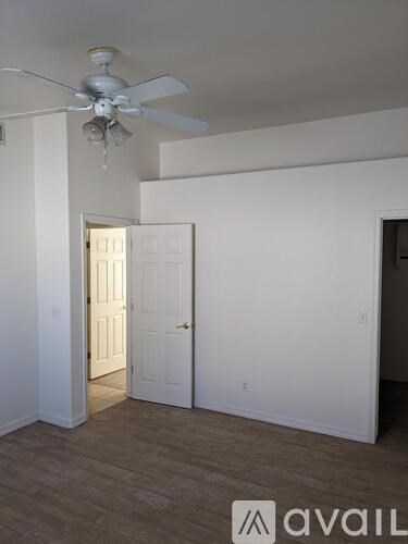 A room with a ceiling fan and two doors.
