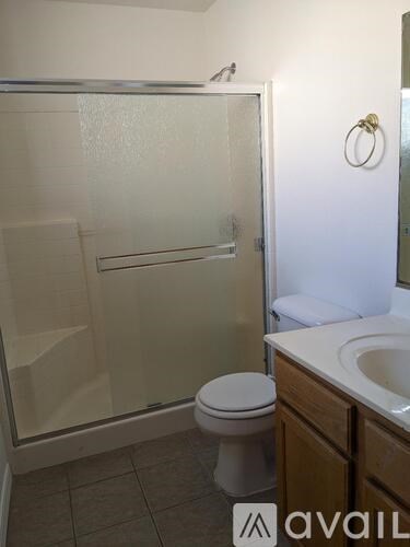 A bathroom with a toilet, sink, and shower.