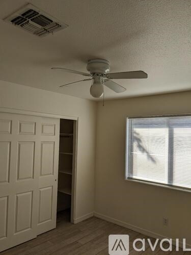 A room with a ceiling fan and a door.