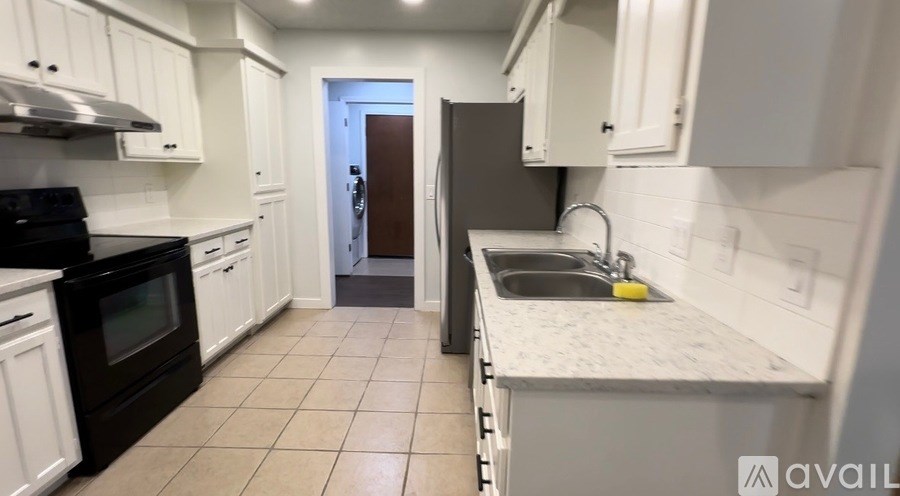 A kitchen with white cabinets and a black stove top oven.
