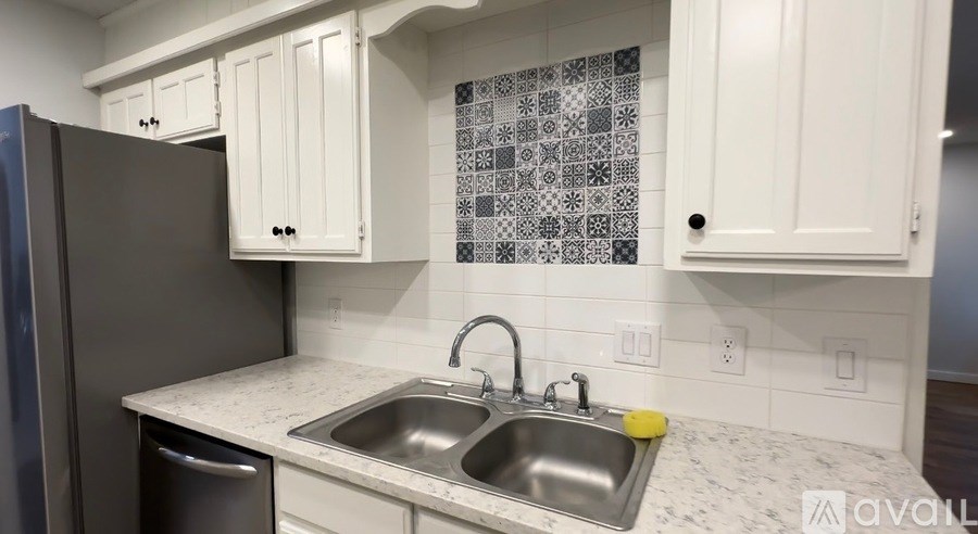 A kitchen with a sink and a fridge.