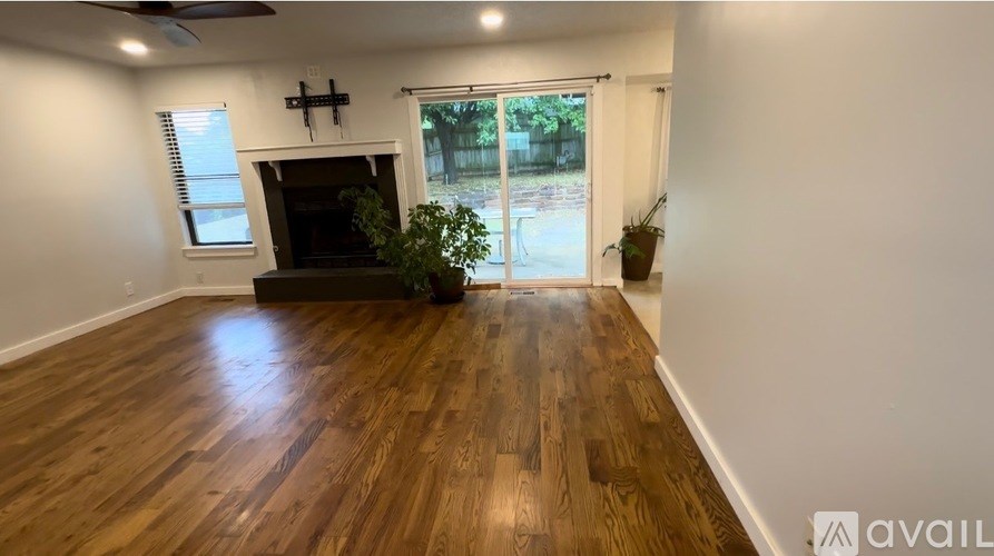 A room with wooden flooring and a fireplace.