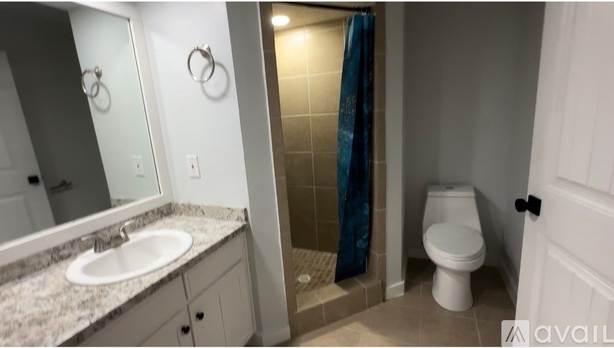 A bathroom with a toilet, sink, and shower.