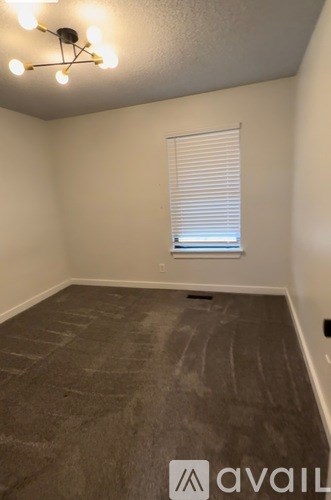 A room with a window covered by blinds and a ceiling fan with lights.
