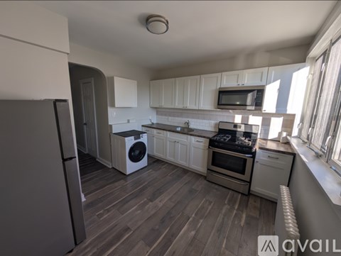 A kitchen with a refrigerator, oven, and microwave.