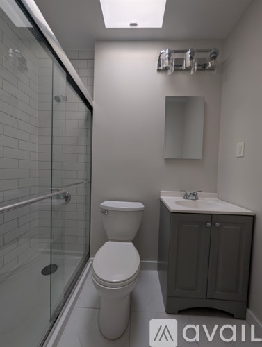 A bathroom with a toilet, sink, and shower.
