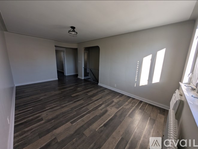 A room with wooden flooring and white walls.