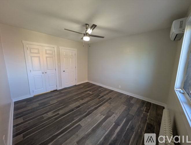 A room with a ceiling fan and two doors.