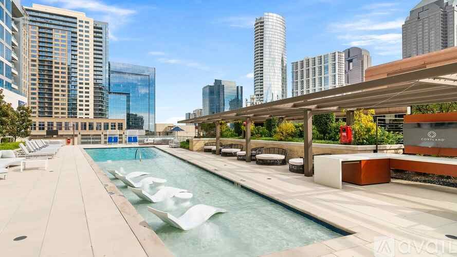 A pool area with a view of the city skyline.