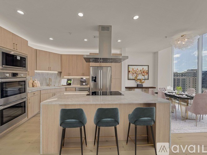 A modern kitchen with a large island and bar stools.